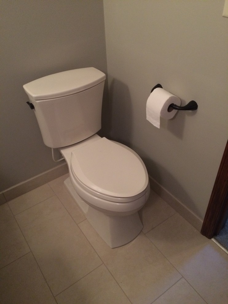 Klassisk inredning av ett mellanstort toalett, med öppna hyllor, skåp i mellenmörkt trä, en toalettstol med separat cisternkåpa, beige kakel, grå väggar, klinkergolv i porslin, ett fristående handfat och bänkskiva i kvarts