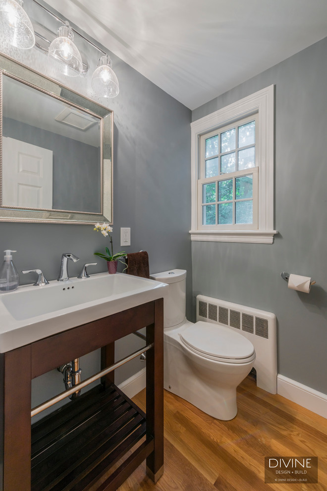Kleine Eklektische Gästetoilette mit offenen Schränken, dunklen Holzschränken, Toilette mit Aufsatzspülkasten, grauer Wandfarbe, braunem Holzboden, Aufsatzwaschbecken, Mineralwerkstoff-Waschtisch und braunem Boden in Boston