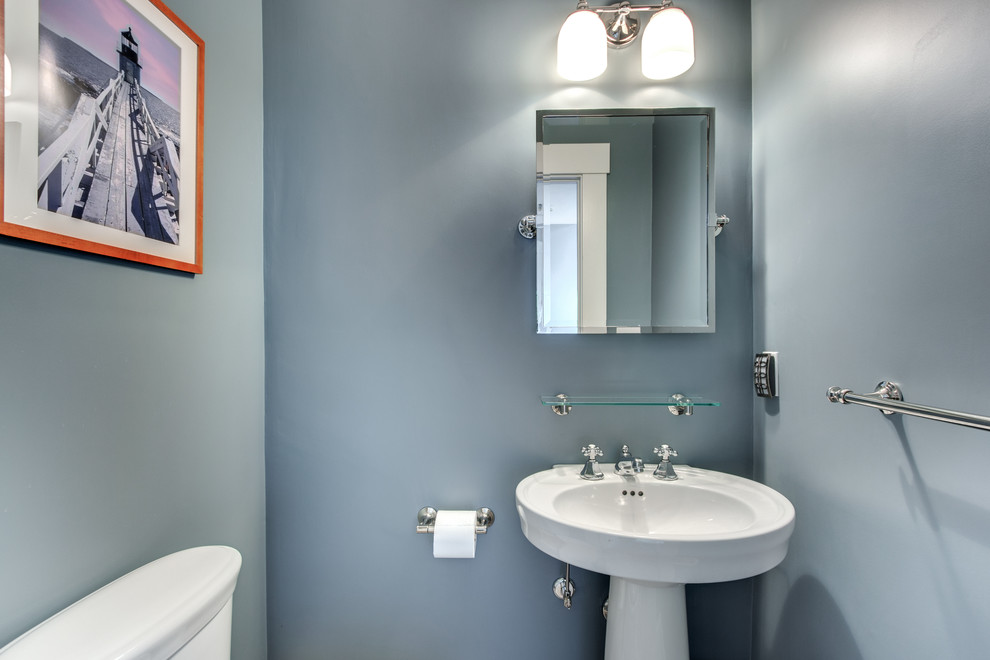 Imagen de aseo tradicional pequeño con paredes azules, lavabo con pedestal y sanitario de dos piezas