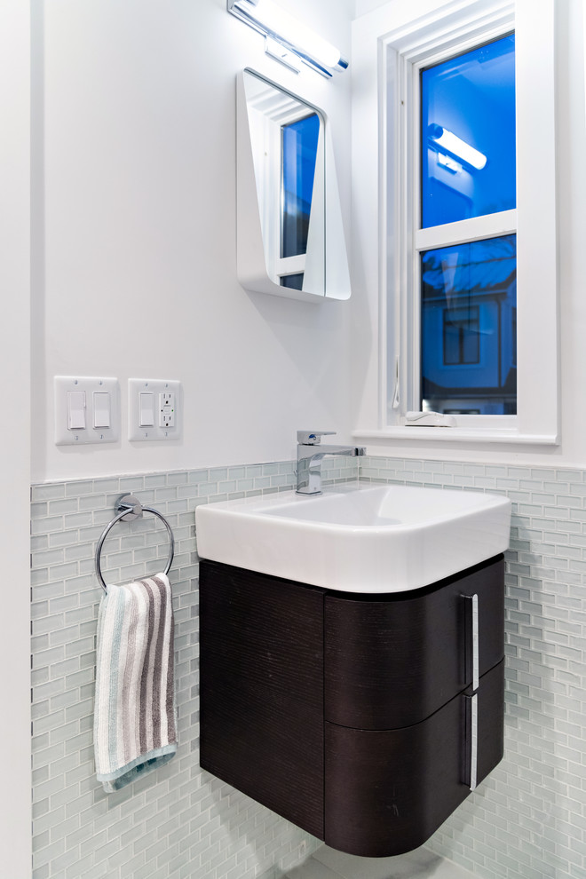 Kleine Moderne Gästetoilette mit flächenbündigen Schrankfronten, dunklen Holzschränken, Glasfliesen, weißer Wandfarbe, integriertem Waschbecken, Quarzwerkstein-Waschtisch und weißer Waschtischplatte in Boston