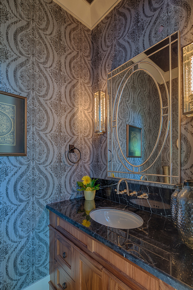 バンクーバーにある小さなトラディショナルスタイルのおしゃれなトイレ・洗面所 (アンダーカウンター洗面器、落し込みパネル扉のキャビネット、中間色木目調キャビネット、青い壁) の写真