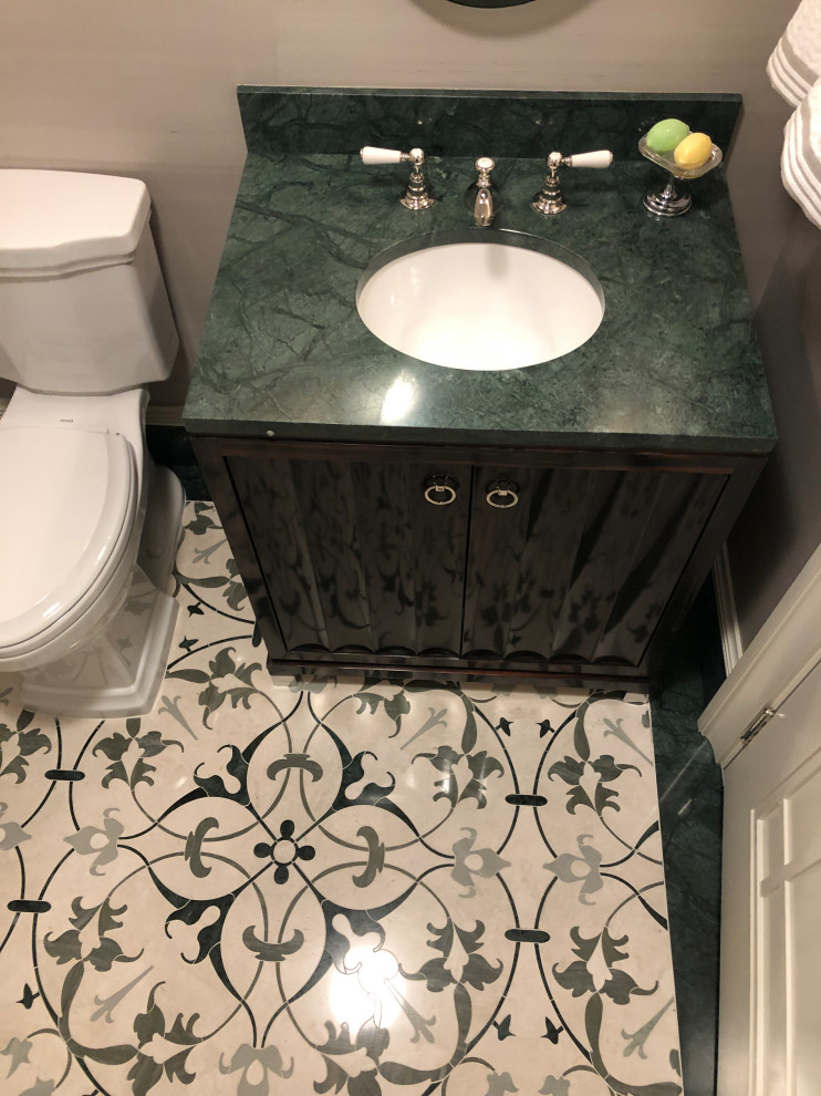 Small traditional cloakroom in New York with freestanding cabinets, brown cabinets, a one-piece toilet, beige walls, mosaic tile flooring, a wall-mounted sink, marble worktops, green floors, green worktops and a freestanding vanity unit.