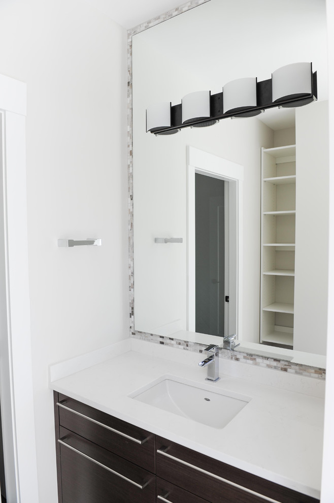 Esempio di un bagno di servizio design con ante lisce, piastrelle bianche, pareti bianche, pavimento in terracotta, lavabo integrato, top in superficie solida, pavimento grigio e ante marroni