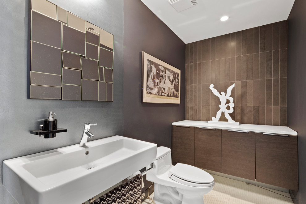 Пример оригинального дизайна: туалет в стиле лофт с плоскими фасадами, темными деревянными фасадами, унитазом-моноблоком, коричневой плиткой, коричневыми стенами, подвесной раковиной, белым полом и белой столешницей