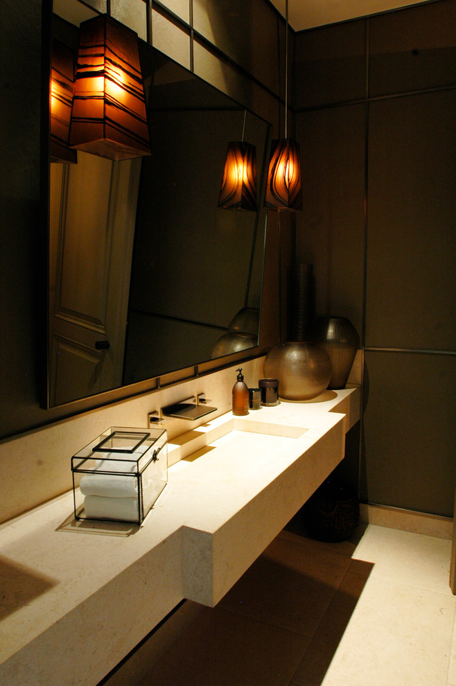 Стильный дизайн: большой туалет в стиле неоклассика (современная классика) с врезной раковиной, столешницей из известняка, бежевой плиткой, плиткой из листового камня, коричневыми стенами и полом из известняка - последний тренд