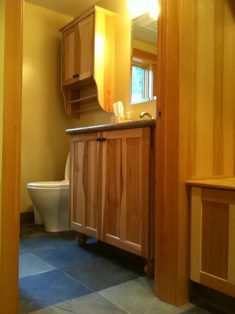 Esempio di un piccolo bagno di servizio american style con lavabo sottopiano, ante in legno chiaro, WC monopezzo, piastrelle grigie, pareti bianche e pavimento in gres porcellanato