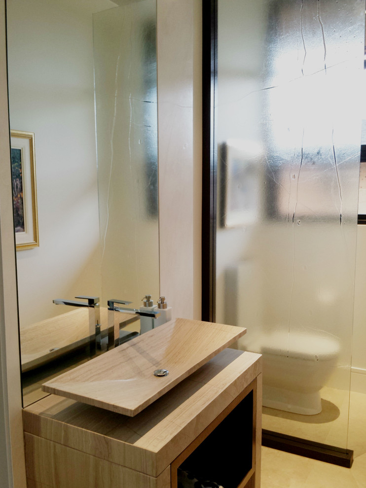 Foto på ett mellanstort funkis toalett, med öppna hyllor, marmorbänkskiva och skåp i ljust trä