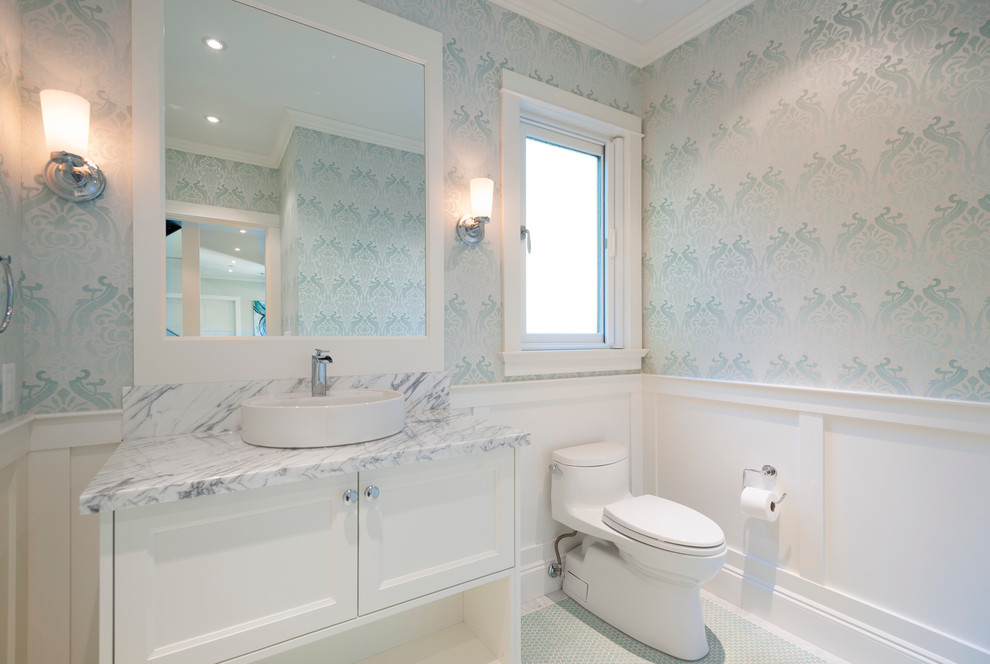 Large transitional porcelain tile powder room photo in Vancouver with a vessel sink, recessed-panel cabinets, white cabinets, marble countertops, a one-piece toilet and blue walls