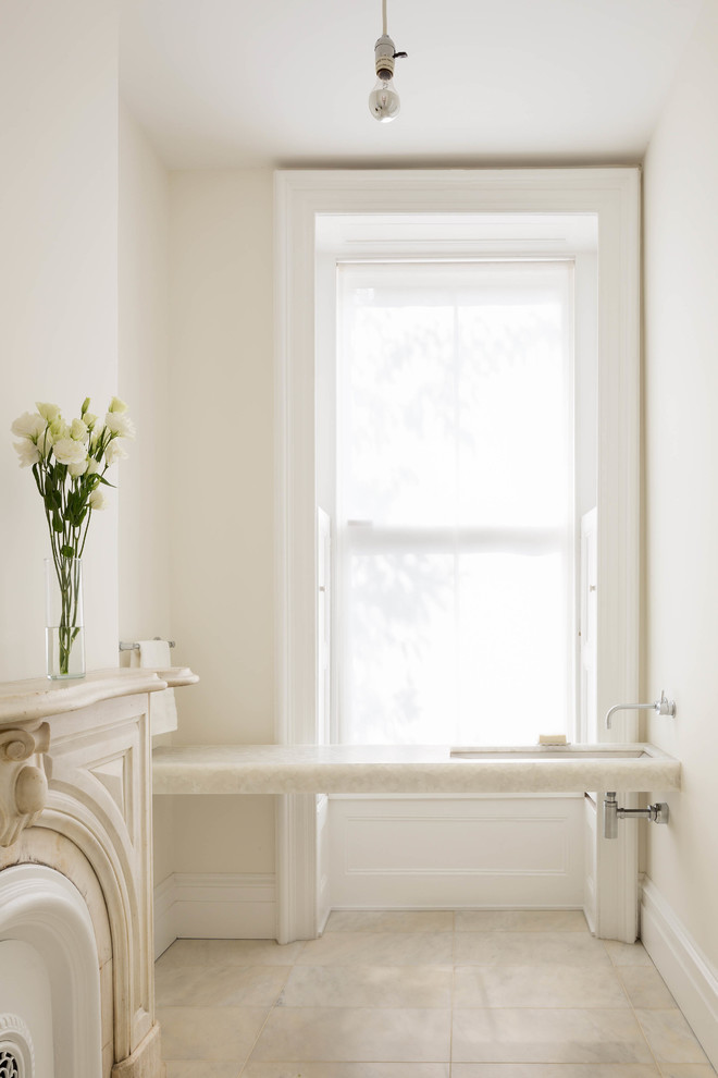 Aménagement d'un WC et toilettes classique avec un lavabo encastré, un plan de toilette en onyx, un mur blanc et un sol en marbre.