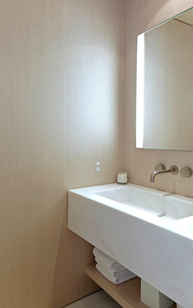 Idées déco pour un WC et toilettes moderne en bois clair avec un placard sans porte et un lavabo intégré.