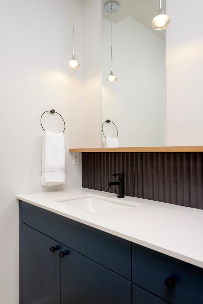 Inspiration for a medium sized modern cloakroom in Seattle with flat-panel cabinets, blue cabinets, black tiles, ceramic tiles, white walls, a submerged sink, engineered stone worktops, white worktops and a built in vanity unit.