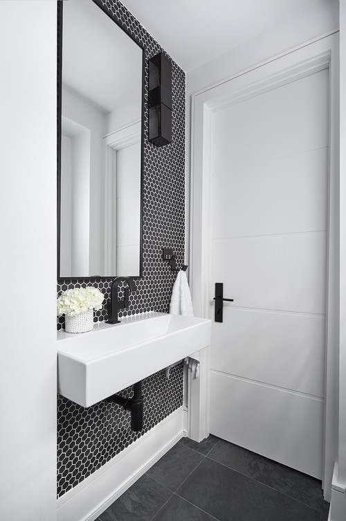 A white bathroom door with a black door handle on a long backplate