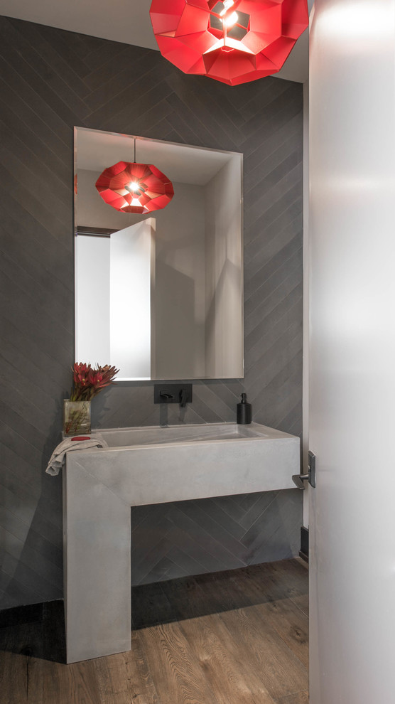 Ispirazione per un grande bagno di servizio design con lavabo integrato, piastrelle grigie, parquet scuro e pareti grigie