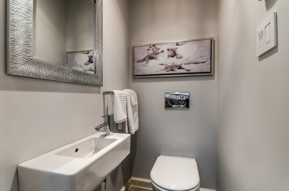 Esempio di un piccolo bagno di servizio minimal con lavabo sospeso, WC sospeso e pareti grigie