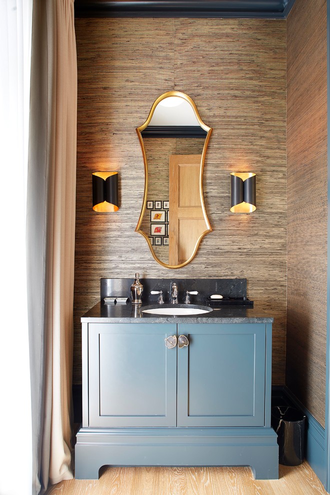 Idee per un bagno di servizio chic con consolle stile comò, ante blu, pareti marroni, parquet chiaro, lavabo sottopiano, pavimento beige e top nero