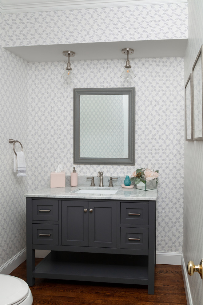 Small farmhouse medium tone wood floor and brown floor powder room photo in Boston with shaker cabinets, gray cabinets, gray walls, an undermount sink, marble countertops and white countertops