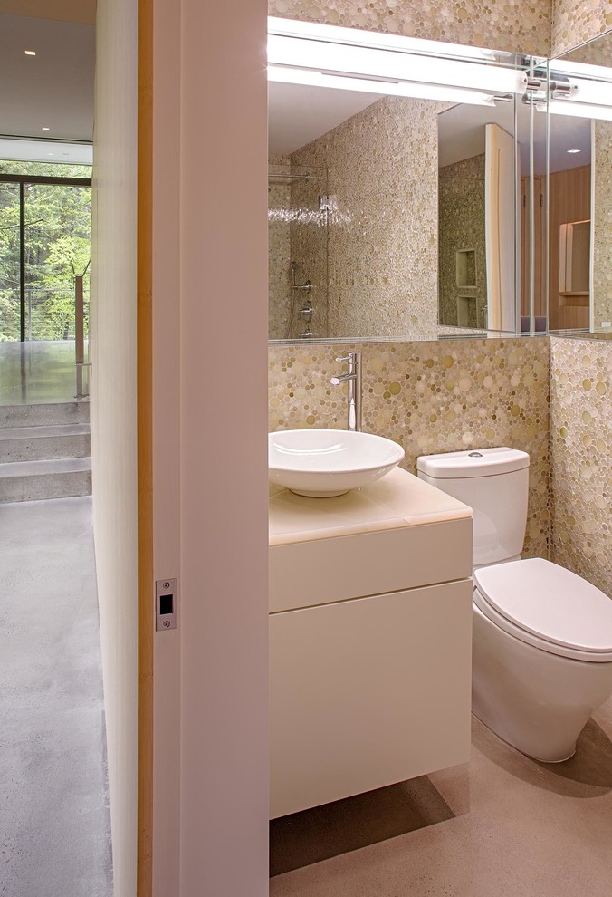 Idées déco pour un petit WC et toilettes moderne avec un placard à porte plane, un plan de toilette en marbre, WC à poser, un carrelage beige, un carrelage en pâte de verre et un mur beige.