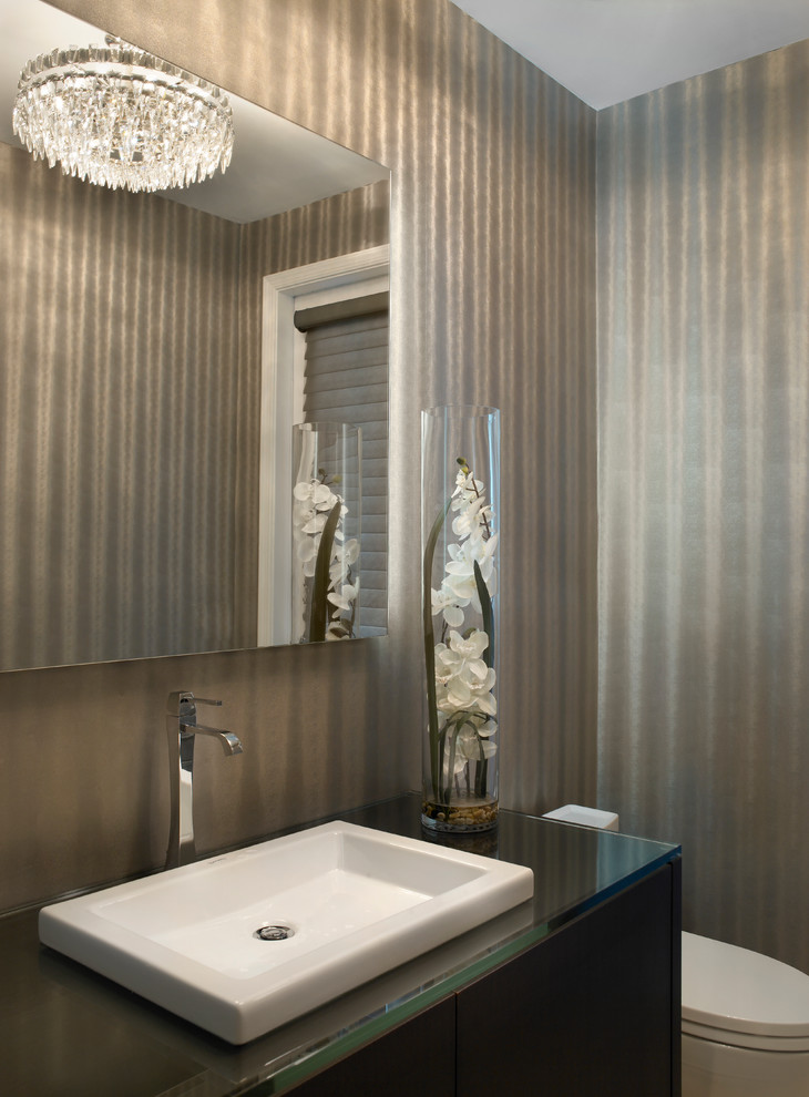Esempio di un piccolo bagno di servizio moderno con ante lisce, ante in legno bruno, WC a due pezzi, pareti beige, lavabo da incasso e top in vetro