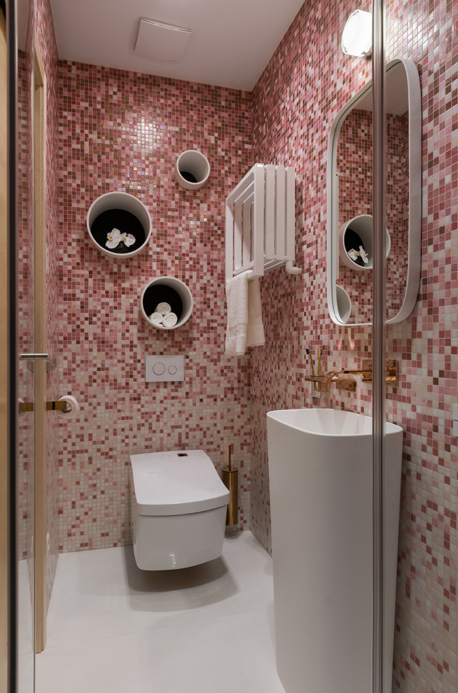 Exempel på ett modernt toalett, med en vägghängd toalettstol, rosa kakel, ett piedestal handfat, vitt golv och mosaik