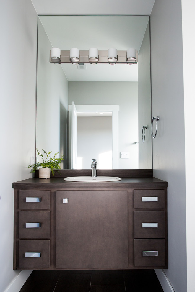 Example of a small trendy black tile and ceramic tile ceramic tile powder room design in Minneapolis with flat-panel cabinets, dark wood cabinets, gray walls, a drop-in sink and wood countertops