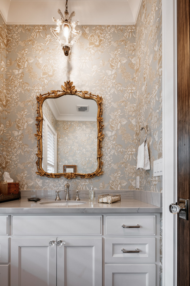 Inspiration for a transitional powder room remodel in Houston with recessed-panel cabinets, white cabinets, gray walls, an undermount sink and gray countertops