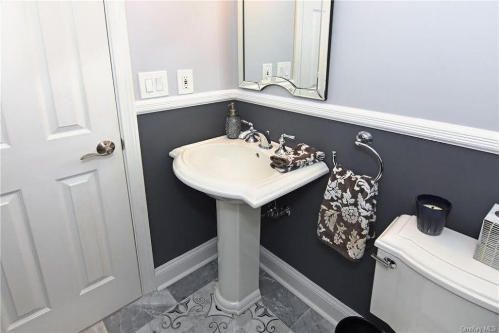 Cette image montre un petit WC et toilettes traditionnel avec WC séparés, un carrelage noir et blanc, un mur gris, un sol en marbre, un lavabo de ferme, un sol multicolore, meuble-lavabo sur pied et boiseries.