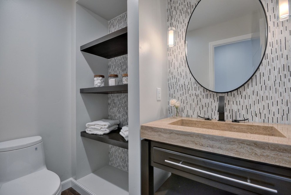 Powder room - small contemporary multicolored tile and glass tile laminate floor and brown floor powder room idea in San Francisco with flat-panel cabinets, black cabinets, a one-piece toilet, gray walls, an integrated sink, quartzite countertops and brown countertops