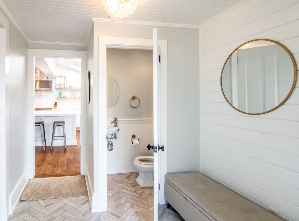 Idee per un piccolo bagno di servizio stile americano con pareti blu, lavabo sospeso, WC a due pezzi, pavimento in gres porcellanato e pavimento marrone