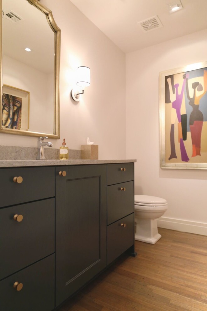 Foto på ett mellanstort funkis toalett, med en toalettstol med separat cisternkåpa, vita väggar, ljust trägolv, ett undermonterad handfat, granitbänkskiva, möbel-liknande och svarta skåp