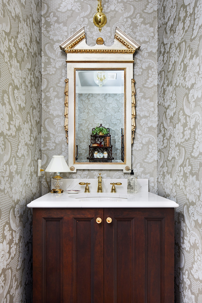 Пример оригинального дизайна: маленький туалет в классическом стиле с темными деревянными фасадами, разноцветными стенами, врезной раковиной и белой столешницей для на участке и в саду