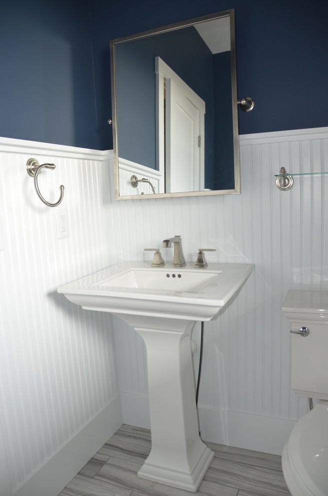 ミネアポリスにあるお手頃価格の小さなトラディショナルスタイルのおしゃれなトイレ・洗面所 (青い壁、磁器タイルの床、ペデスタルシンク、ベージュの床) の写真