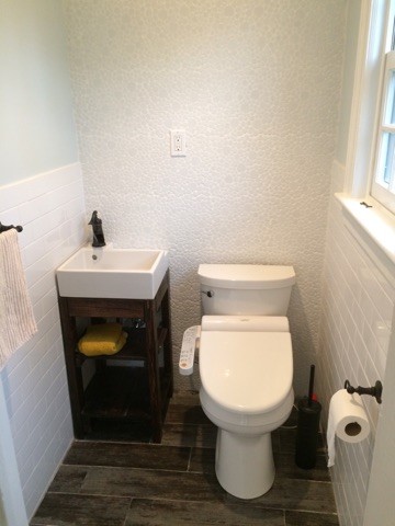 Aménagement d'un petit WC et toilettes contemporain en bois foncé avec un placard sans porte, un carrelage blanc, un carrelage de pierre, un mur bleu, un sol en carrelage de porcelaine et une vasque.
