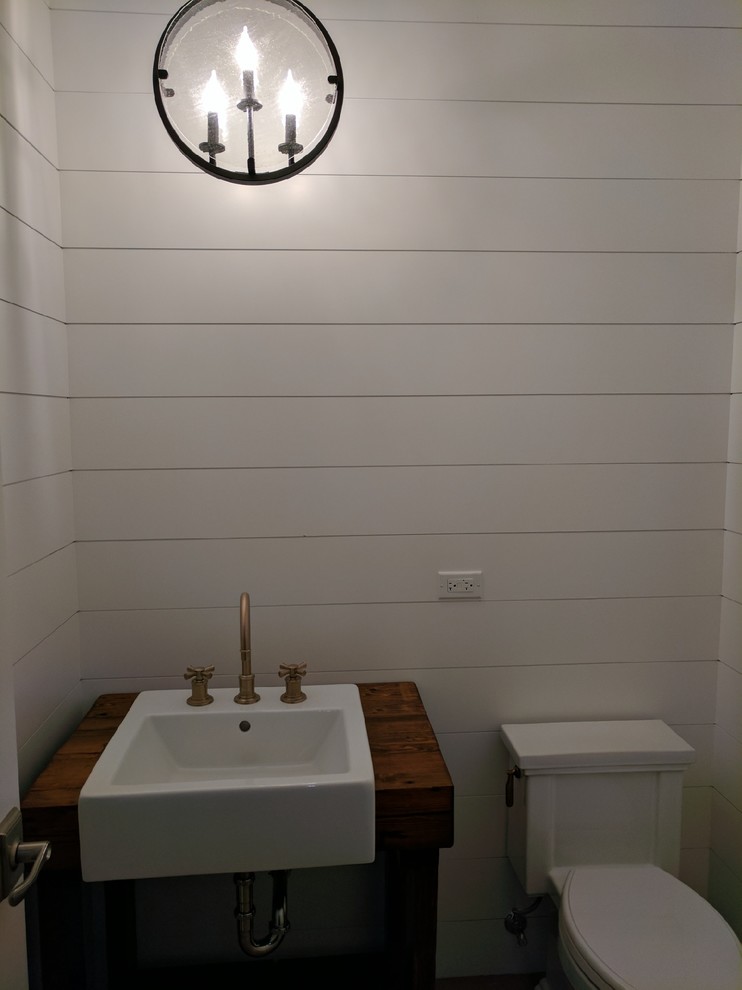 Idée de décoration pour un WC et toilettes champêtre de taille moyenne avec WC séparés, un mur blanc, un lavabo posé et un plan de toilette en bois.