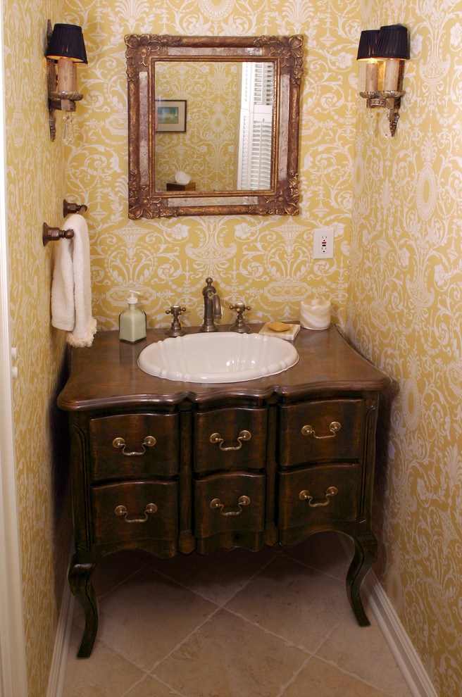 Cette photo montre un WC et toilettes craftsman en bois foncé avec un lavabo posé, un placard en trompe-l'oeil, un sol en carrelage de céramique, un plan de toilette en bois, un carrelage beige, un mur jaune et un plan de toilette marron.