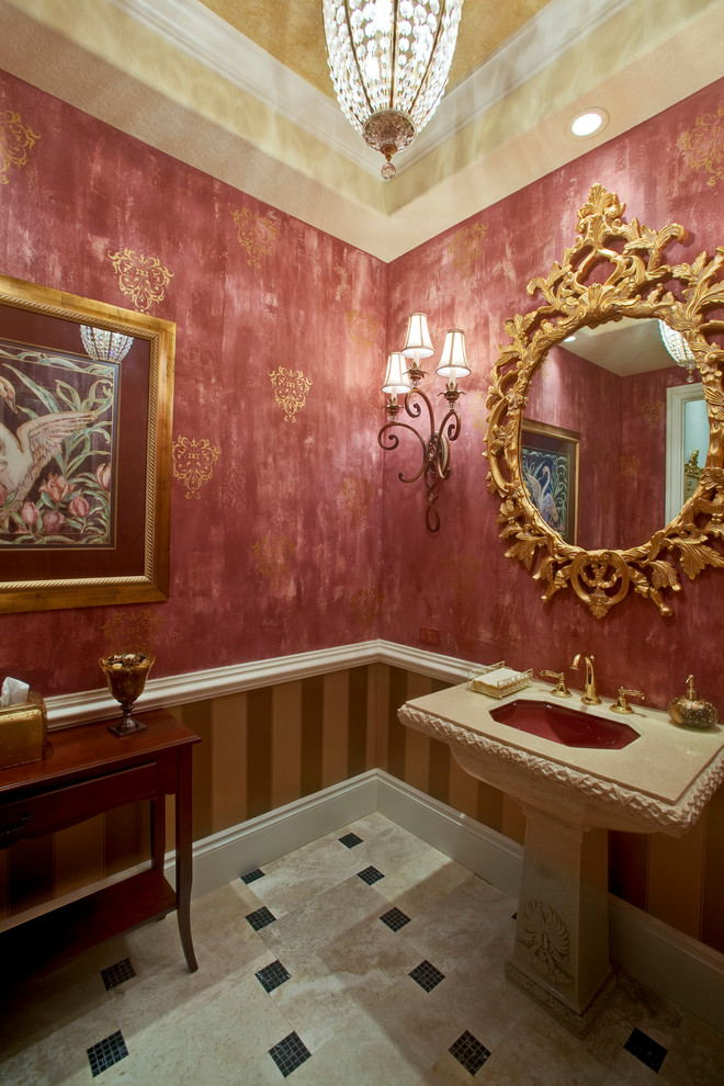 オーランドにあるお手頃価格の小さな地中海スタイルのおしゃれなトイレ・洗面所 (赤い壁、トラバーチンの床、ペデスタルシンク、ベージュの床、大理石の洗面台) の写真