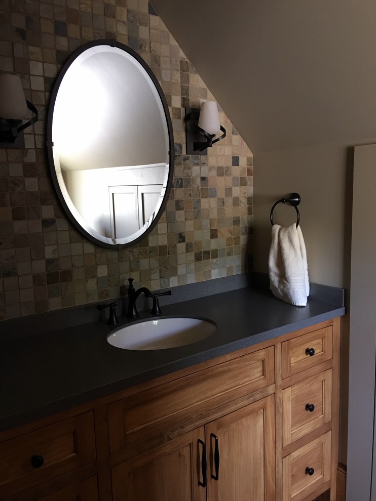Inredning av ett rustikt litet toalett, med skåp i shakerstil, skåp i mellenmörkt trä, en toalettstol med separat cisternkåpa, beige kakel, beige väggar, ett undermonterad handfat, granitbänkskiva och mosaik