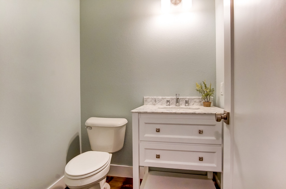 Small classic cloakroom in Other with recessed-panel cabinets, white cabinets, a two-piece toilet, grey walls, medium hardwood flooring, a submerged sink, marble worktops, brown floors and white worktops.