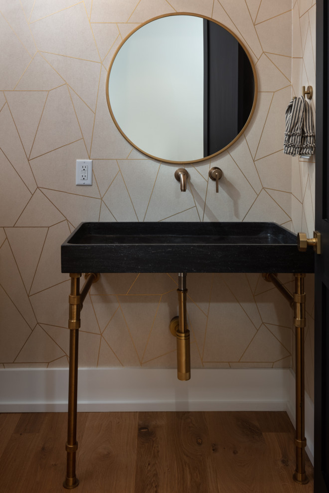 Photo of a large farmhouse cloakroom in New Orleans with black cabinets, a two-piece toilet, a pedestal sink, brown floors, a floating vanity unit and wallpapered walls.