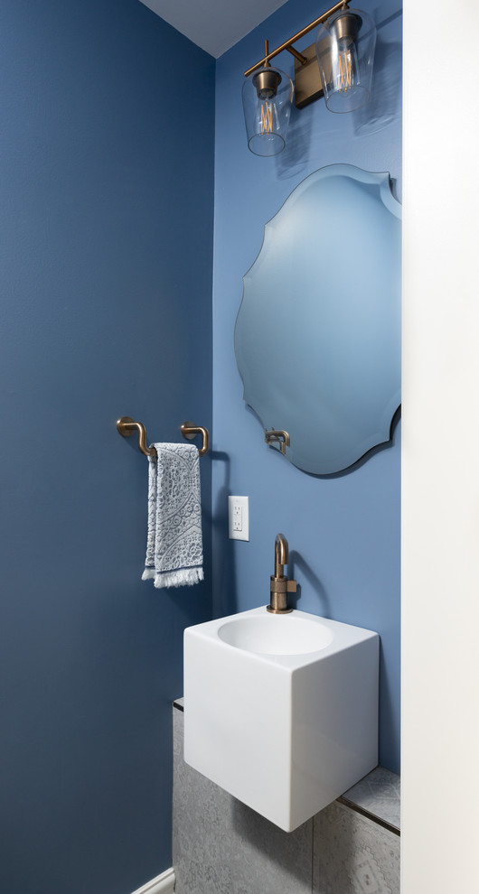 オタワにある小さなトランジショナルスタイルのおしゃれなトイレ・洗面所 (一体型トイレ	、青い壁、磁器タイルの床、壁付け型シンク、グレーの床) の写真