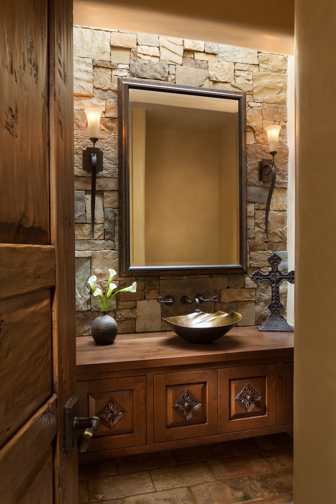 Diseño de aseo de estilo americano con armarios tipo mueble, puertas de armario de madera oscura, lavabo sobreencimera y suelo marrón