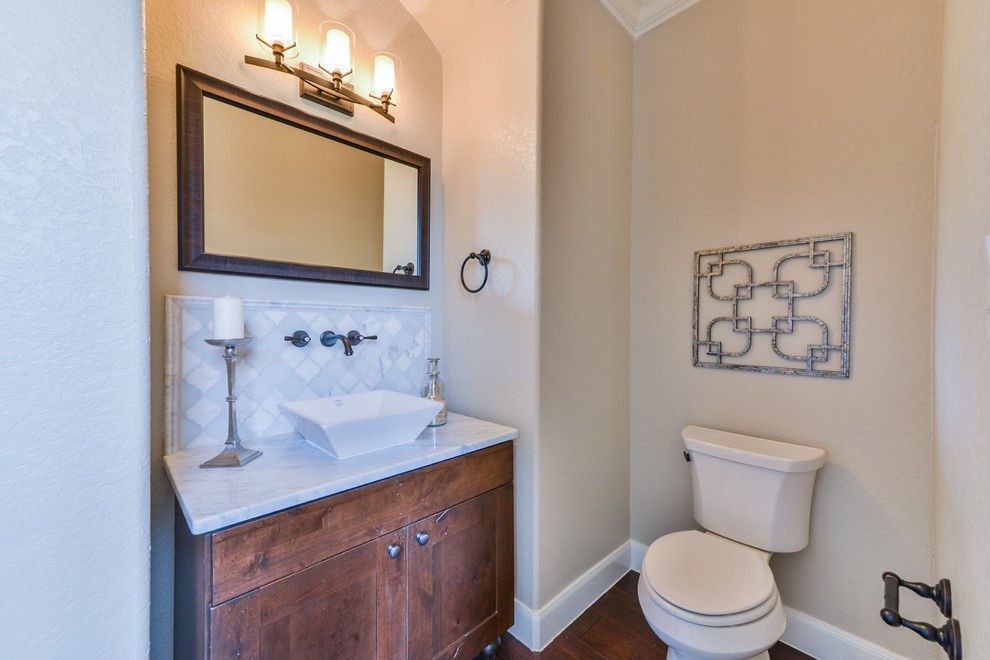 Idée de décoration pour un WC et toilettes tradition en bois foncé de taille moyenne avec un placard à porte shaker, WC séparés, un carrelage gris, du carrelage en marbre, un mur beige, un sol en bois brun, une vasque, un plan de toilette en marbre et un sol marron.