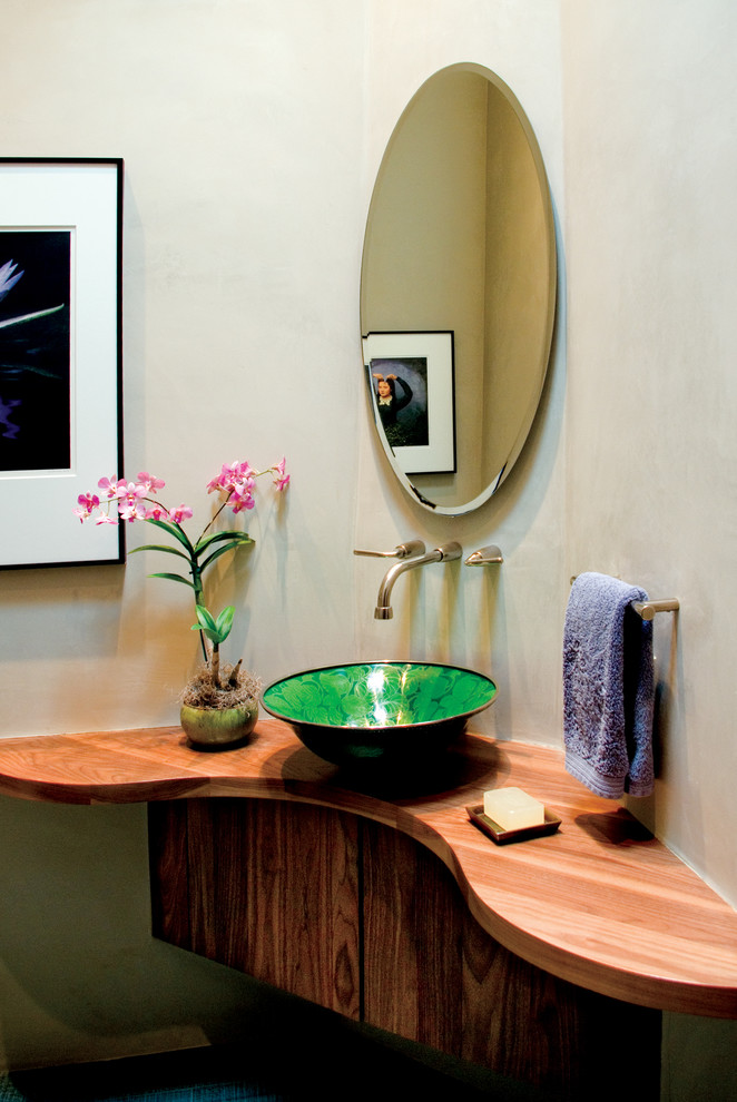 Mediterrane Gästetoilette mit flächenbündigen Schrankfronten, dunklen Holzschränken, beiger Wandfarbe, Aufsatzwaschbecken und Waschtisch aus Holz in Albuquerque