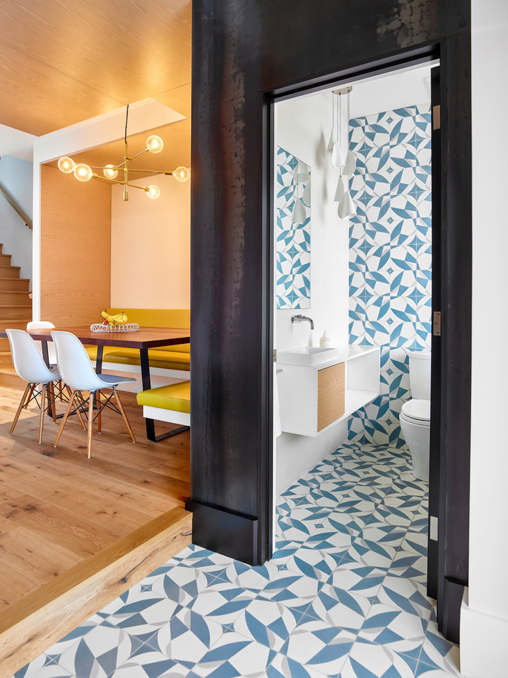 Идея дизайна: туалет в современном стиле с светлыми деревянными фасадами, унитазом-моноблоком, синей плиткой, цементной плиткой, полом из цементной плитки, настольной раковиной, столешницей из искусственного кварца, синим полом и белой столешницей