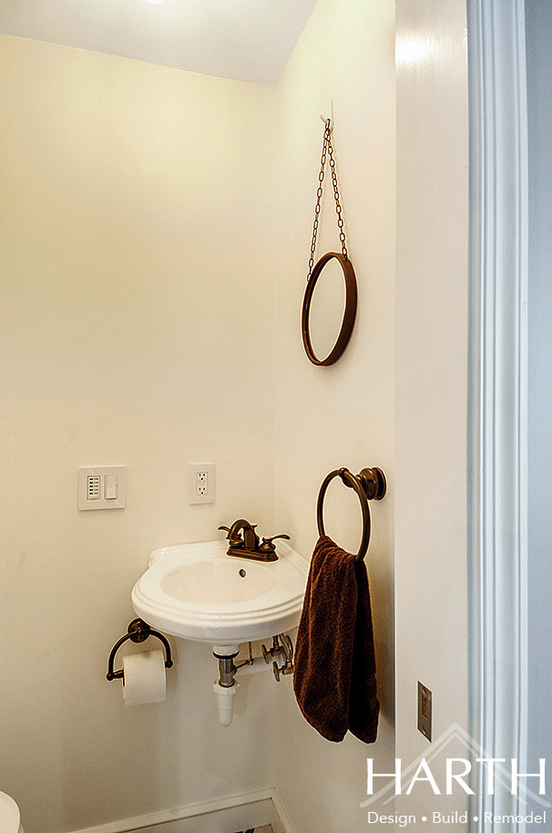 フィラデルフィアにある低価格の小さなカントリー風のおしゃれなトイレ・洗面所 (分離型トイレ、白い壁、磁器タイルの床、壁付け型シンク、黒い床) の写真