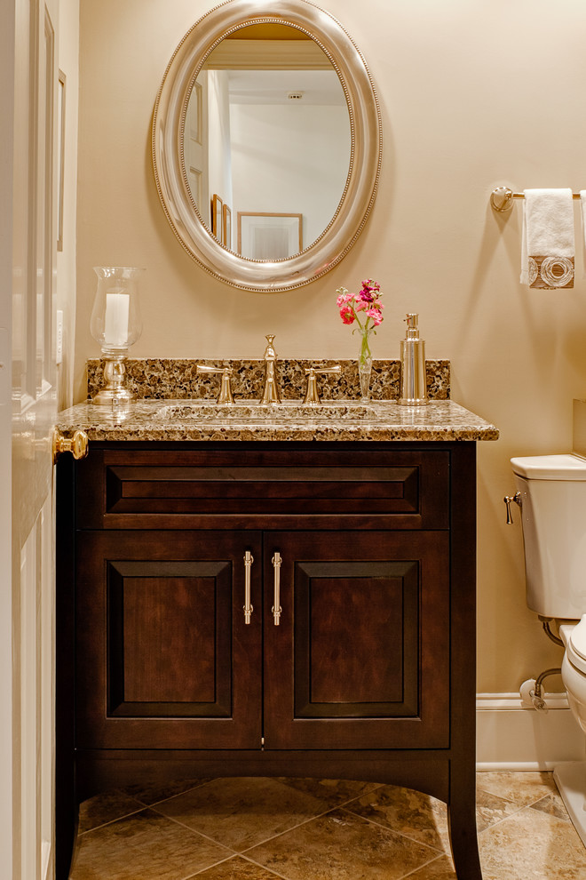 Small elegant multicolored tile porcelain tile powder room photo in Charlotte with an undermount sink, raised-panel cabinets, dark wood cabinets, granite countertops, a two-piece toilet and beige walls