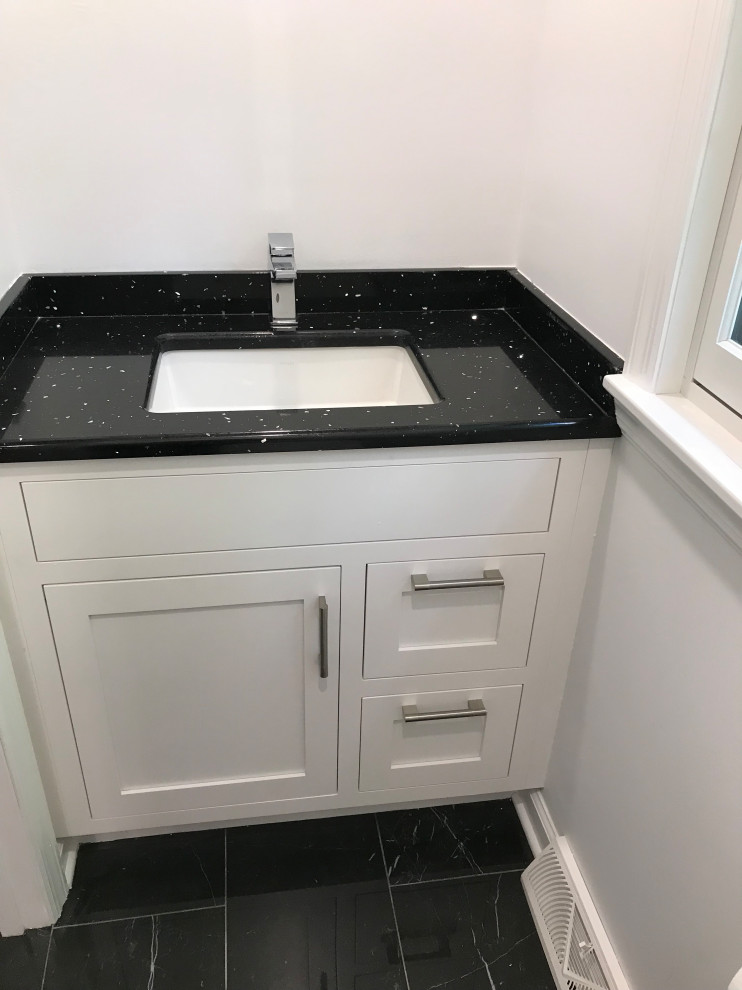 Small traditional cloakroom in New York with recessed-panel cabinets, white cabinets, marble flooring, a submerged sink, engineered stone worktops, black floors and black worktops.