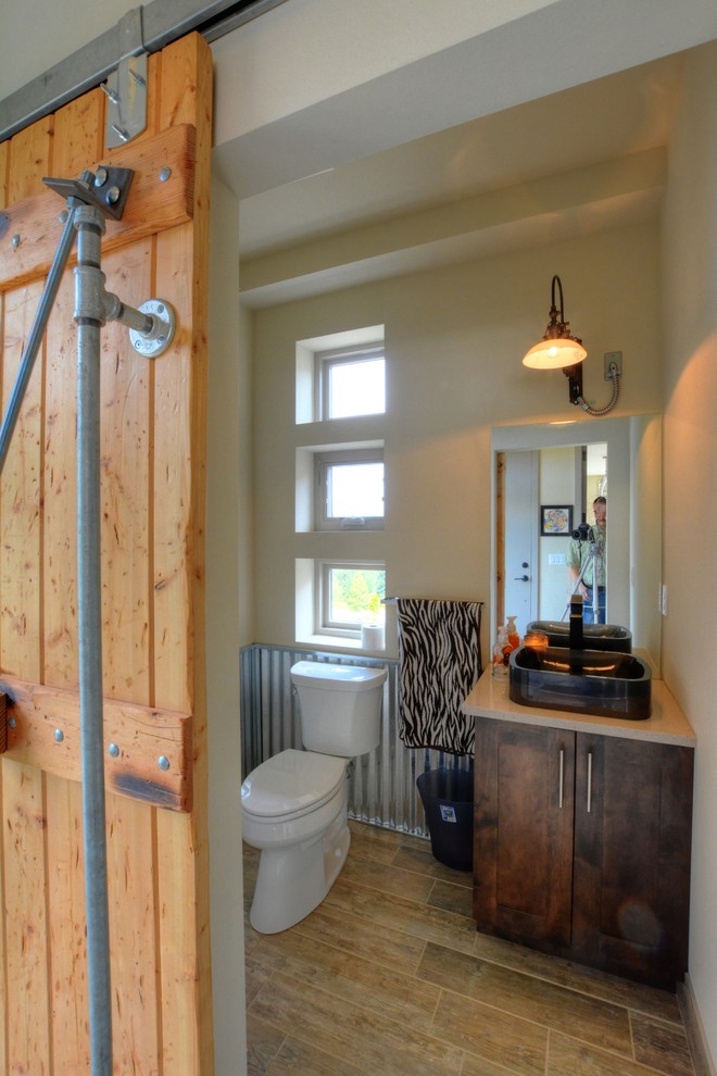 シアトルにある高級な小さなインダストリアルスタイルのおしゃれなトイレ・洗面所 (ペデスタルシンク、シェーカースタイル扉のキャビネット、濃色木目調キャビネット、クオーツストーンの洗面台、グレーのタイル) の写真