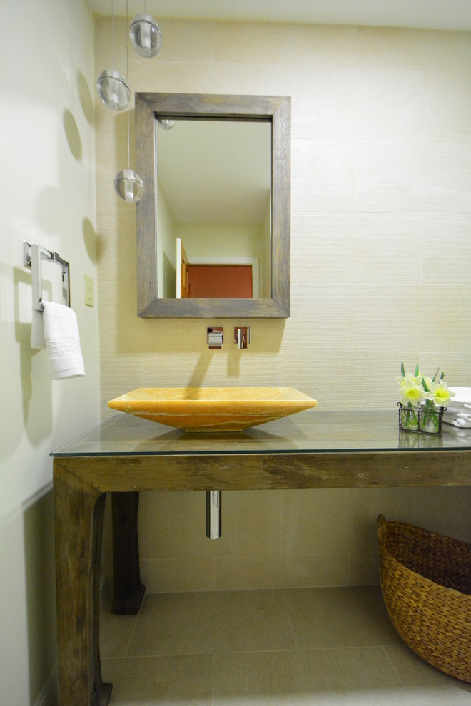 Idee per un bagno di servizio contemporaneo con lavabo a bacinella, consolle stile comò, ante in legno scuro, top in vetro, piastrelle beige e piastrelle in gres porcellanato