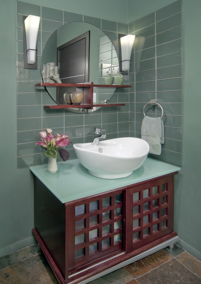 フェニックスにあるアジアンスタイルのおしゃれなトイレ・洗面所 (ベッセル式洗面器、家具調キャビネット、濃色木目調キャビネット、ガラスの洗面台) の写真