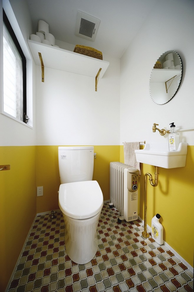 Ispirazione per un bagno di servizio mediterraneo con pareti gialle, lavabo a consolle e pavimento multicolore